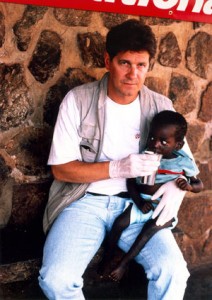 Dan in Rwanda (1994), after the mass killing crisis, helping to feed a child at the Kigali hospital
