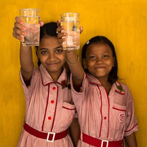 Girls holding water glasses at Splash, Murlidhar Girls School in Kolkata, India.