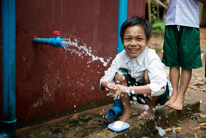 Child at water faucet.