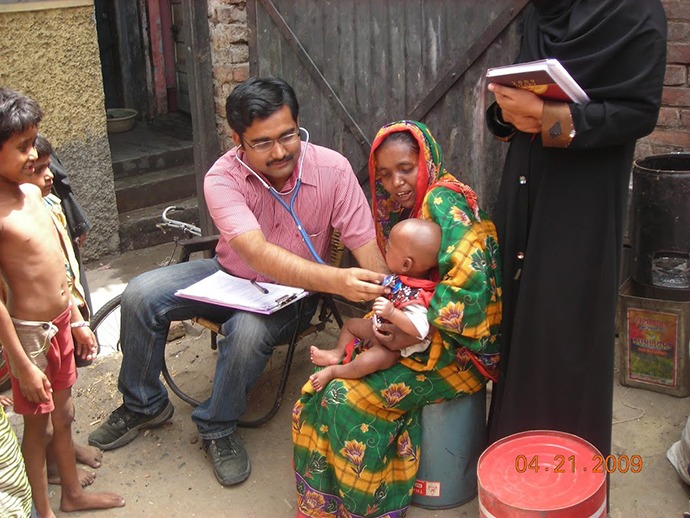 Bandyopadhyay examining an infant in Moradabad, Uttar Pradesh, India.