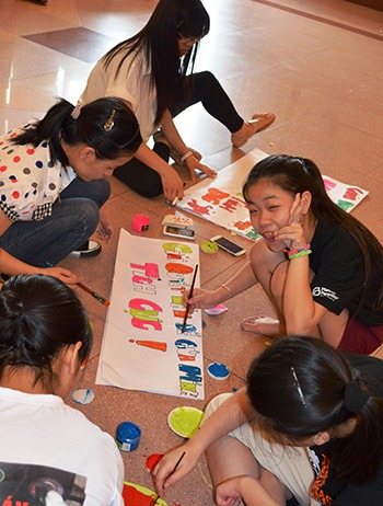 In Vietnam, a group of peer educators create signs with messages about sexual and reproductive health for a large educational event.