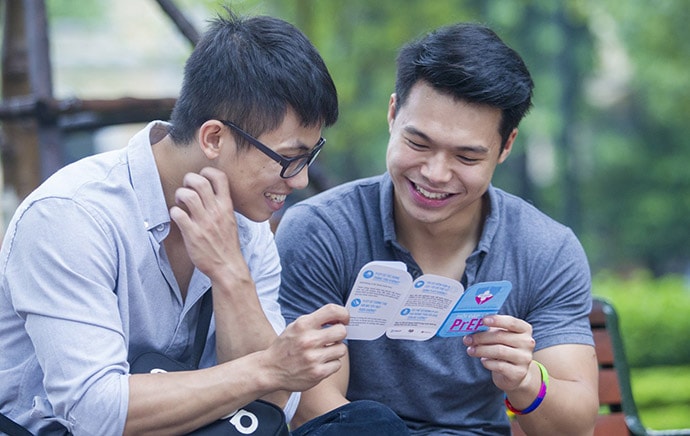 Two young men in Vietnam read a leaflet
