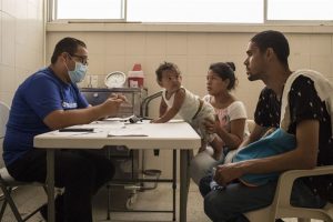 A Venezuelan couple speaks with a physician