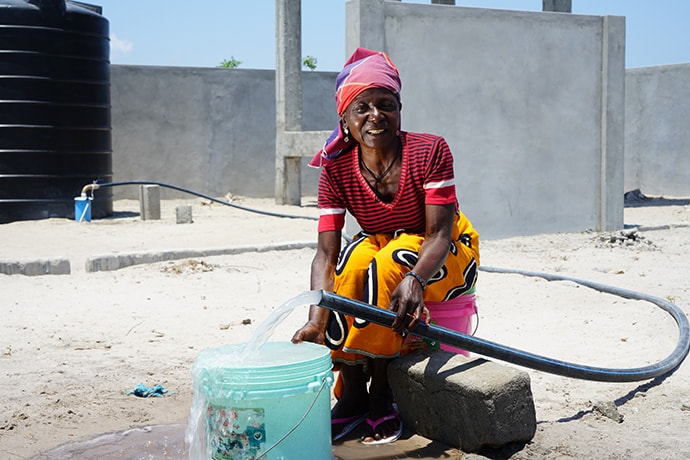 Molia Abdallah, 47, fills a bucket of water