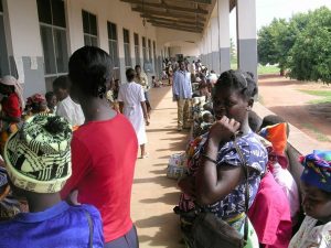 Women in Uganda wait for their turn to see a provider at a health facility