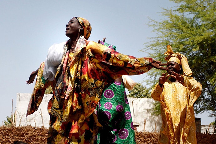Two Senegalese women dancing in celebration