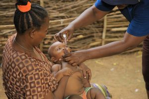 A CGPP community volunteer administers OPV drops