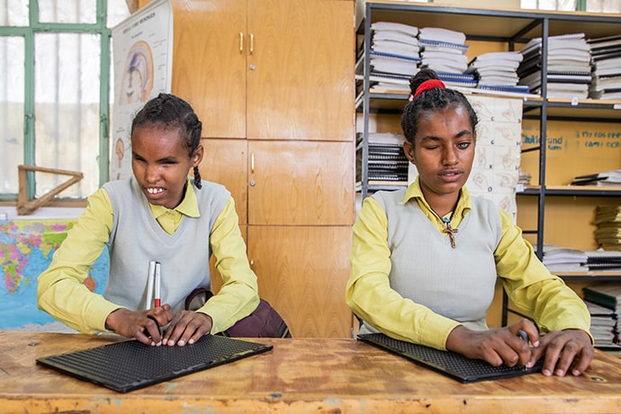 Askale, 16, and Kibnesh, 17, read using braille slates and styluses