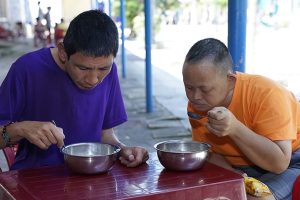 Intellectually disabled men eating