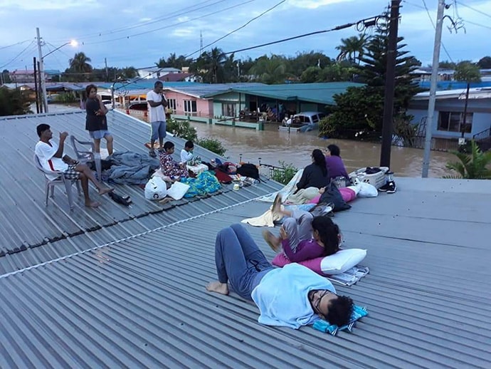 People on roof above flood waters