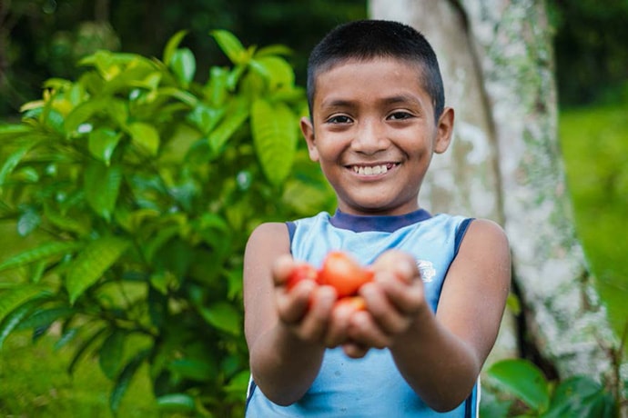 Smiling boy holding produce