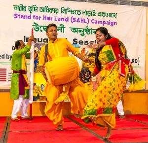 Dancers perform in front of banner