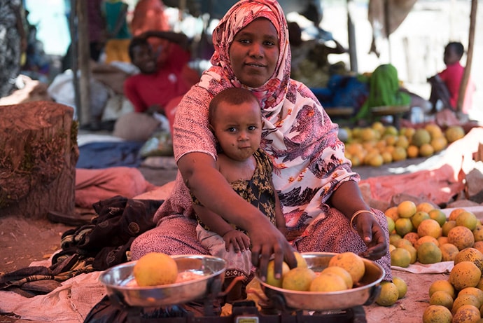 Businesswoman at market holding child