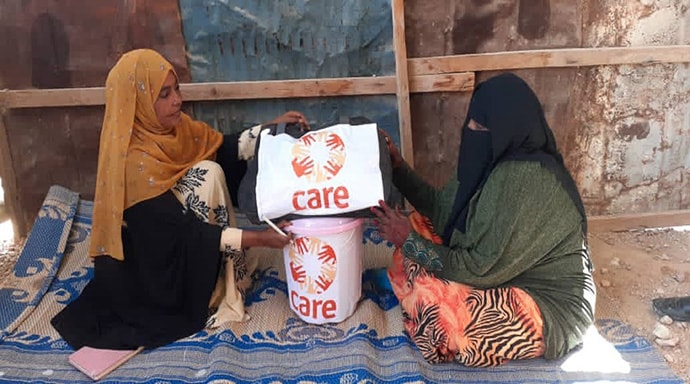 Habib (seated) receiving CARE package