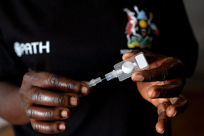 Photo of community health worker demonstrating self-injectable contraception