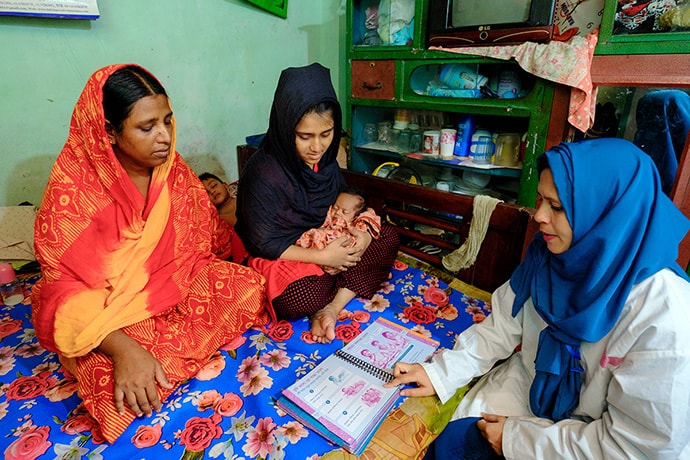 View of mother with baby and health care worker