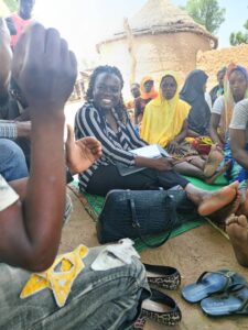 View of Ama seated with farmers