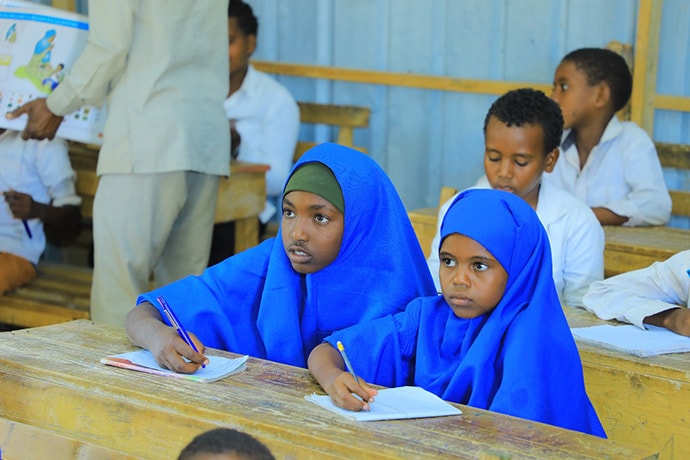 Photo of two girls dressed in blue at desk