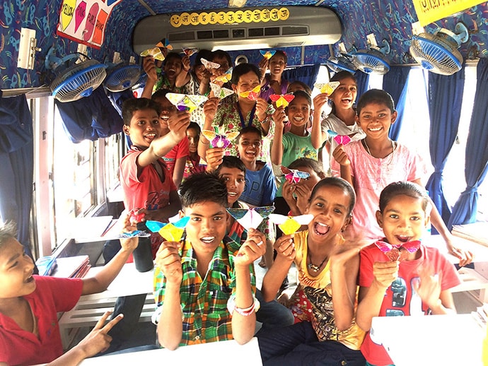 Smiling students show of their crafts on bus