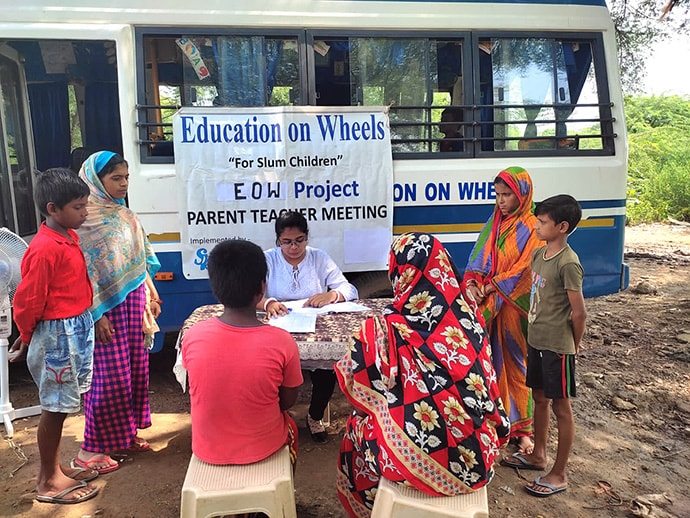 View of meeting outdoors in front of bus