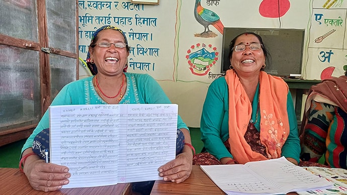 Photo of two women at desk with reading material