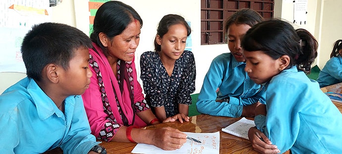 Instructor and students at desk