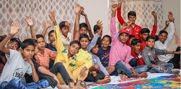 Photo of group of boys raising their hands