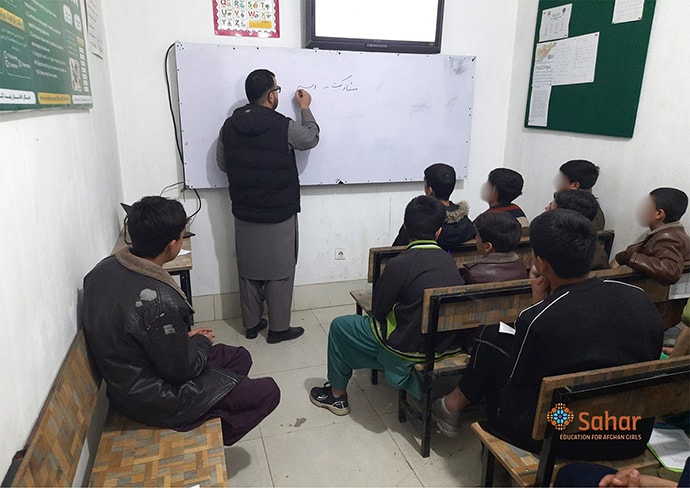 View of young men and teacher in classroom