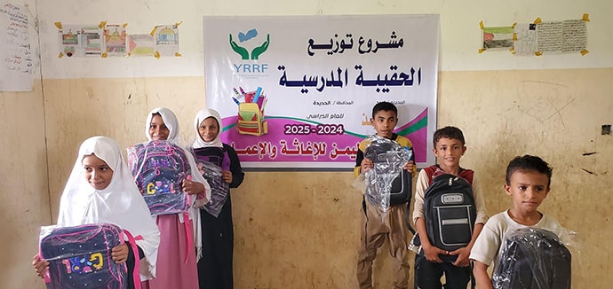 Photo of children with bags in classroom