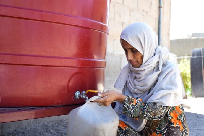 View of woman getting water