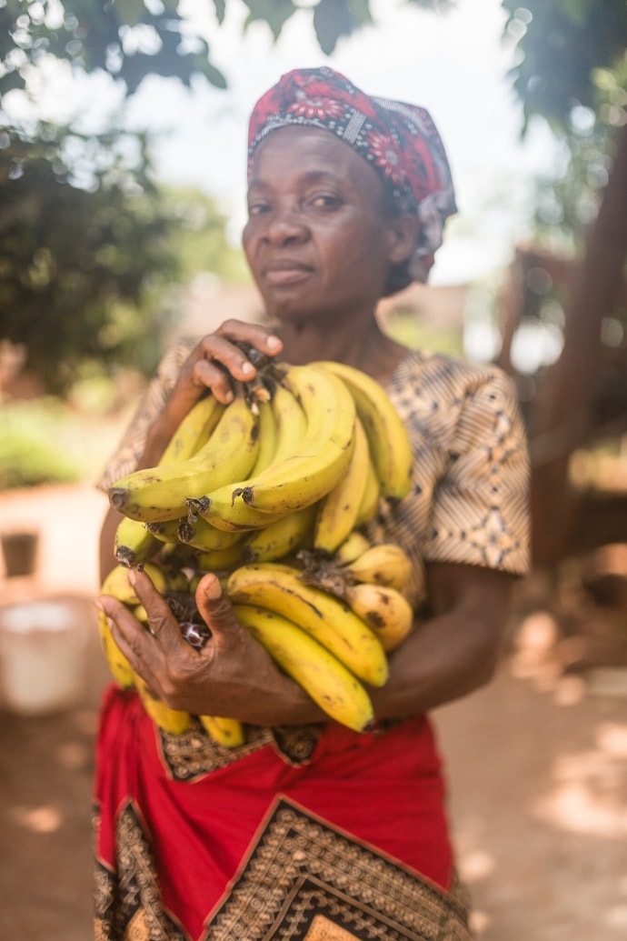 Photo of woman holding bunches of bananas