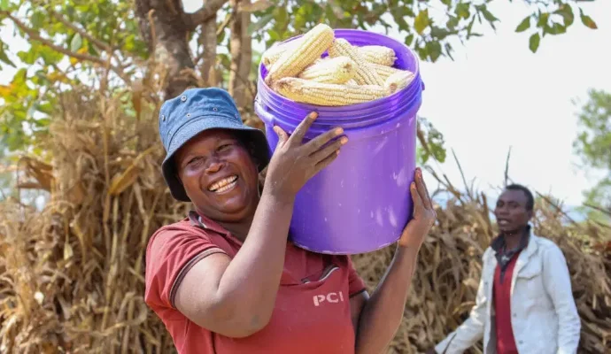 View of woman holding bucket of corn