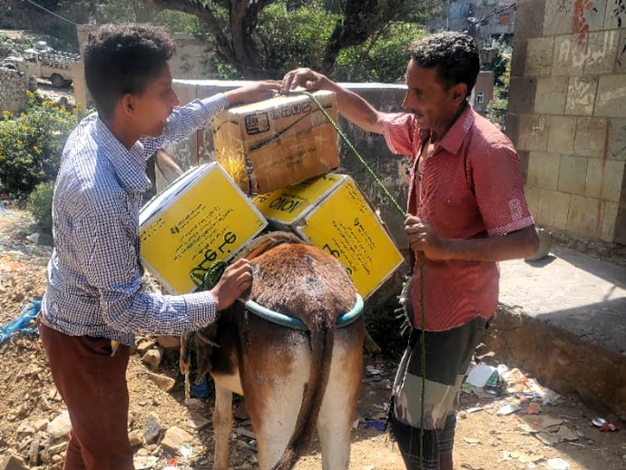 Photo of men loading donkey