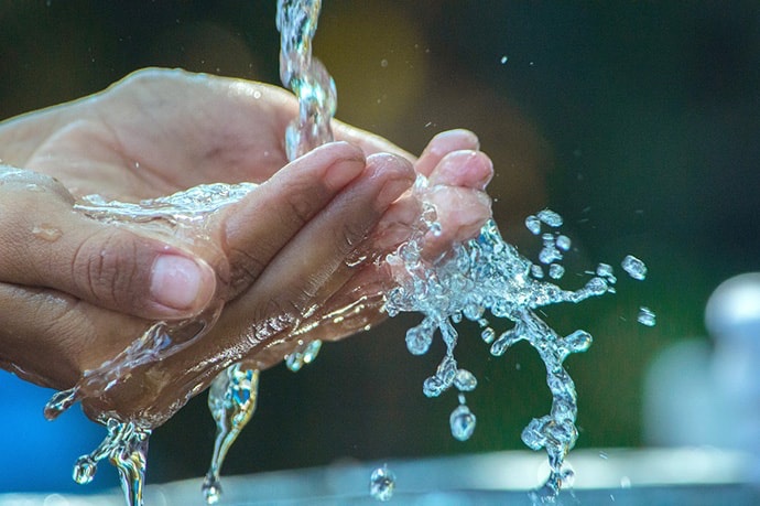 View of water pouring into open hands