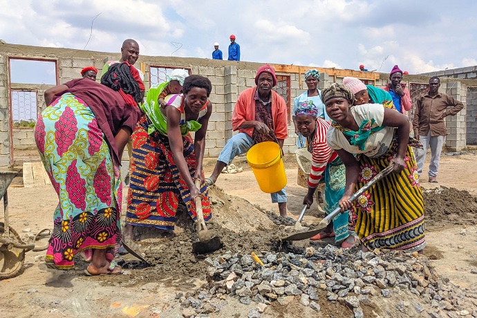 View of men and women mixing concrete