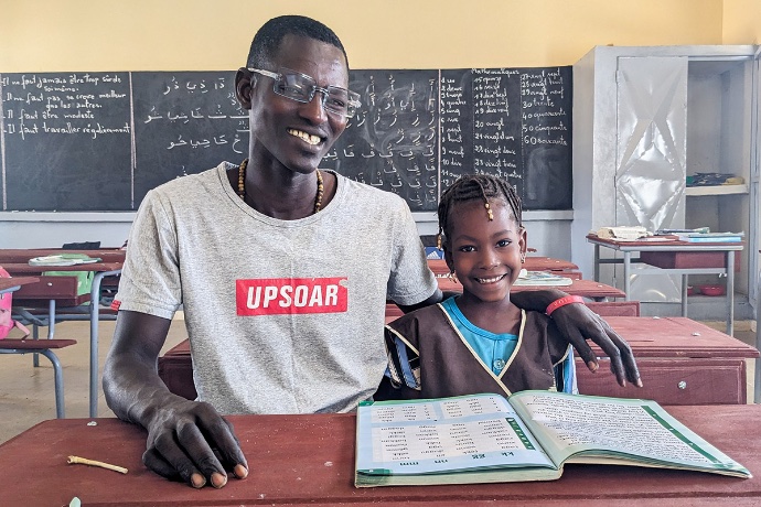 Smiling father and daughter reading in school