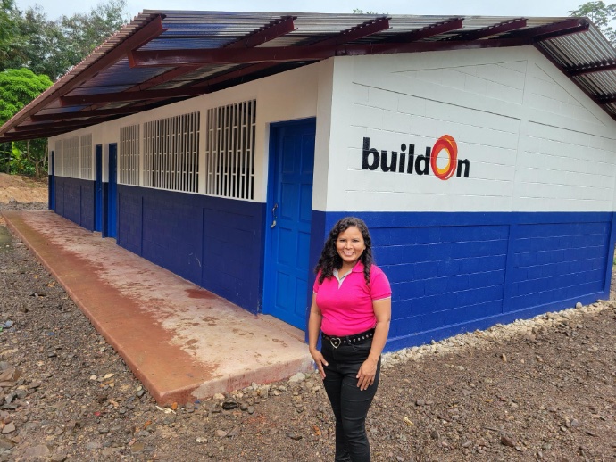 Sandra de Jesús Gurdián posing in front of BuildOn school building