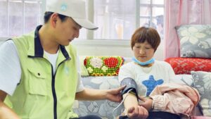 View of healthcare worker measuring blood pressure of patient